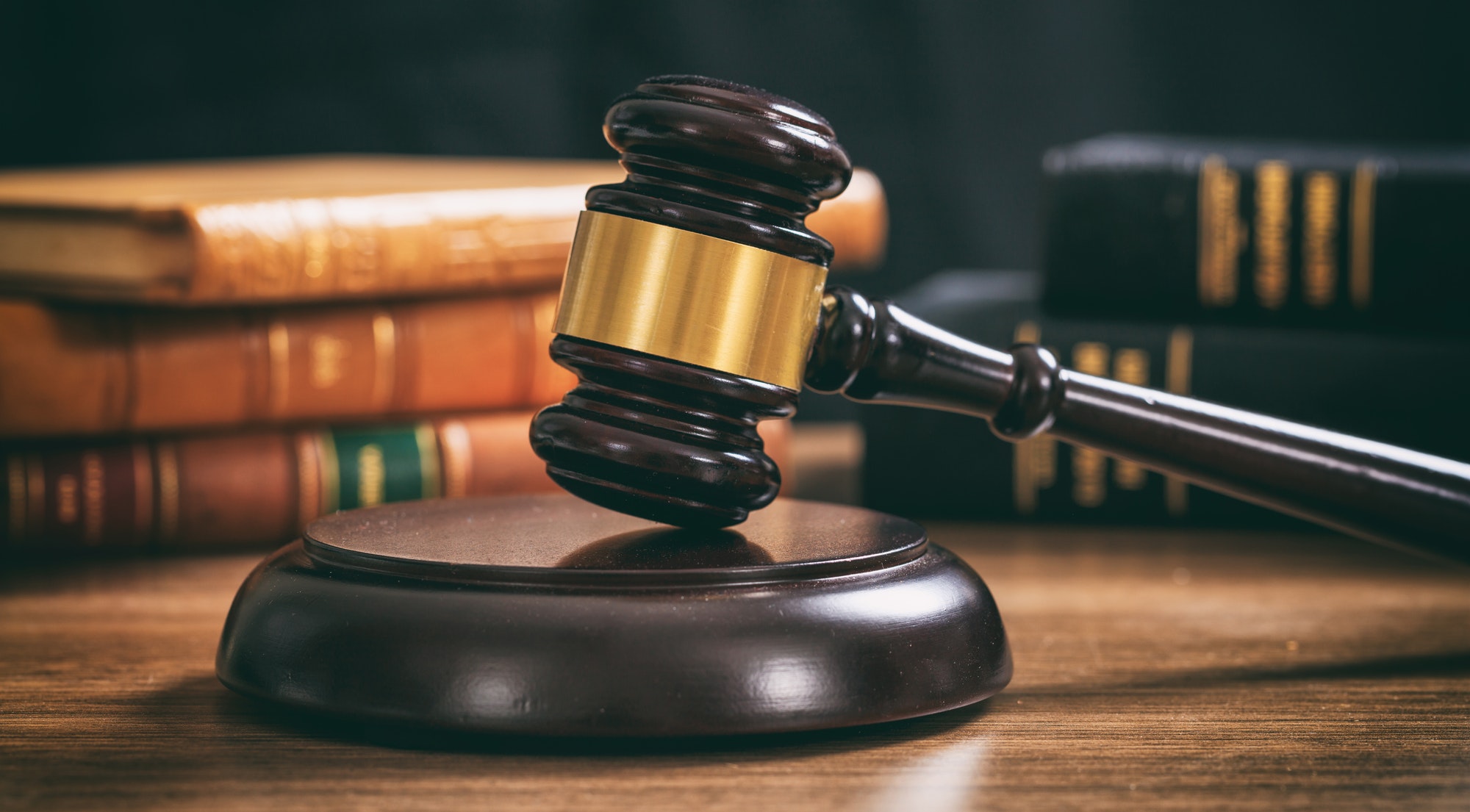 judge gavel on a wooden desk law books background 1